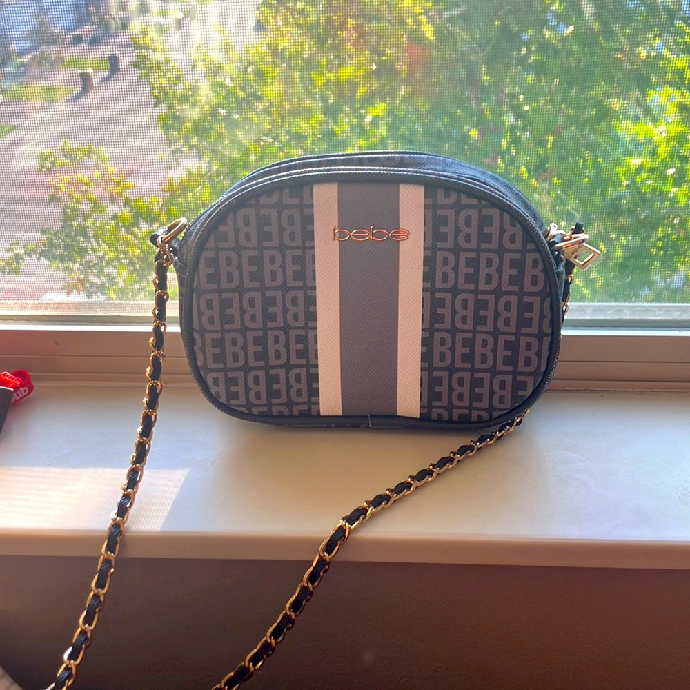 Gray and white Bebe purse with gold and black for the strap